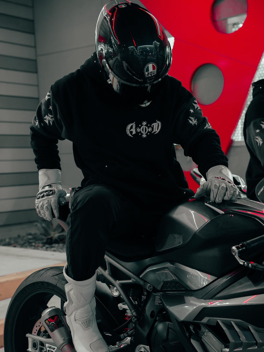 Rider seated on a motorcycle wearing Adapt or Die